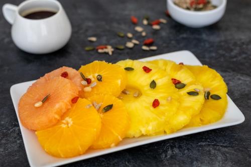a plate of pineapple slices with a cup of coffee at Ibis Styles Chambery Centre Gare in Chambéry