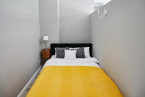 a bedroom with a bed with a yellow blanket at Żółty Apartament DE LUX dla 2 osób Chorzów Katowice in Chorzów