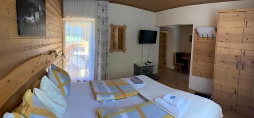 a bedroom with two beds and a television in it at Haus Voithofer in Sankt Johann im Pongau