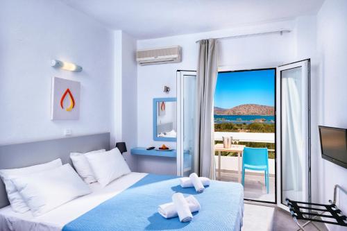 a bedroom with a bed and a view of the ocean at Elounda Krini Hotel in Elounda