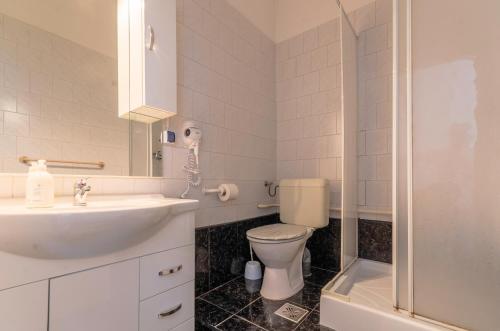 a bathroom with a toilet and a sink and a shower at Eitans Guesthouse in Budapest