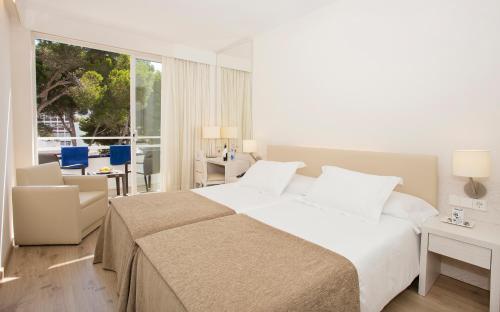 a bedroom with a large bed and a living room at Canyamel Park Hotel & Spa - 4* Sup - Adults only (+16) in Canyamel