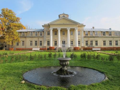 a fountain in front of a large building at Krimuldas Muiža in Sigulda