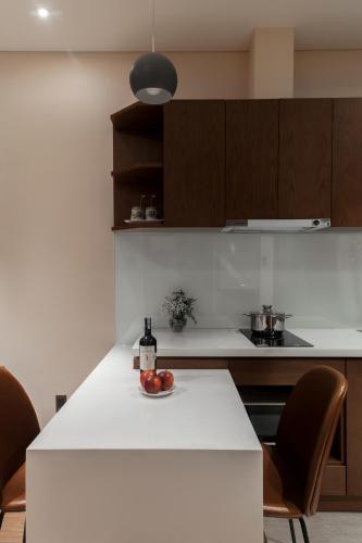 a kitchen with a table with a bottle of wine at DHTS Business Hotel & Apartment in Ho Chi Minh City