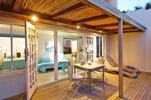 una habitación con mesa y sillas y un dormitorio en Days At Sea Beach Lodge en Trafalgar