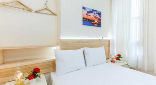 um quarto com uma cama branca e 2 almofadas brancas em Otantik Hotel em Istambul