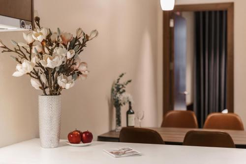a vase of flowers sitting on a table at DHTS Business Hotel & Apartment in Ho Chi Minh City