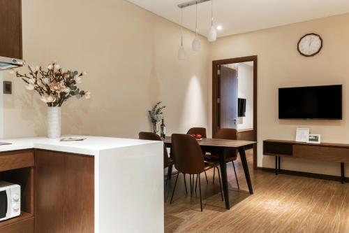 a kitchen and dining room with a table and a tv at DHTS Business Hotel & Apartment in Ho Chi Minh City