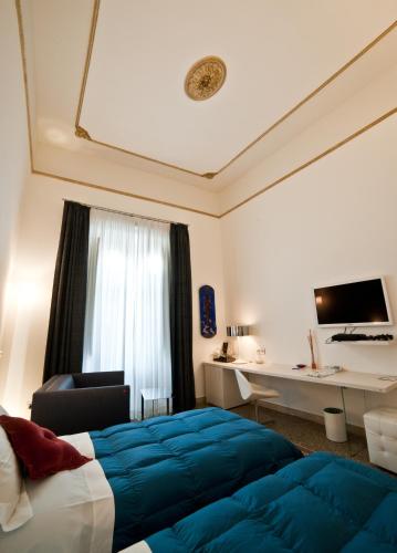a hotel room with a bed and a desk at Town House Cavour in Reggio Calabria