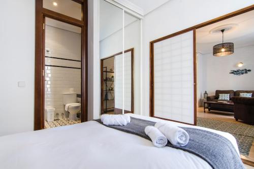 a bedroom with a large white bed with towels on it at 1 bedroom 1 bathroom furnished - Chueca - bright in downtown area - MintyStay in Madrid