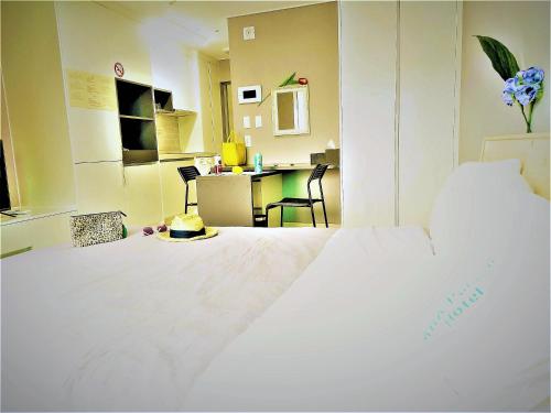 a large white bed in a room with a table at ARA Palace Hotel in Jeju
