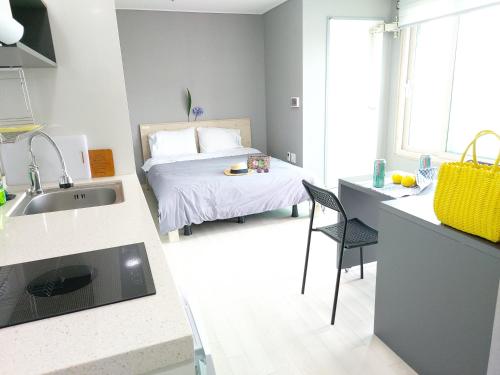 a kitchen with a bed and a sink in a room at ARA Palace Hotel in Jeju