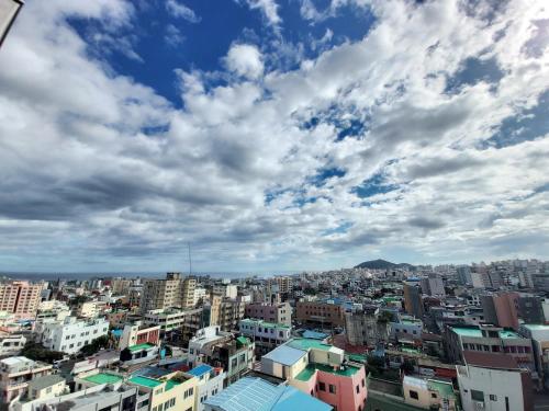 a city under a cloudy sky with buildings at ARA Palace Hotel in Jeju
