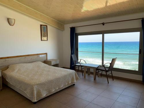 1 dormitorio con cama y vistas al océano en Kaplica Hotel en Famagusta