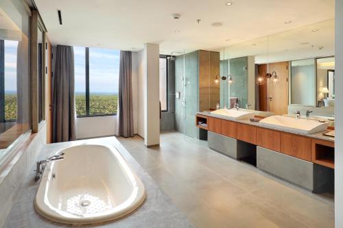 外南夢的住宿－Kokoon Hotel Banyuwangi，大型浴室设有两个盥洗盆和一个大浴缸。