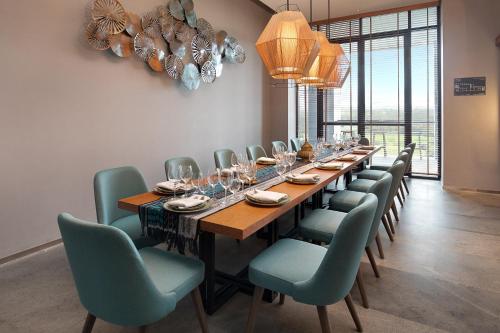 a long dining room with a long table and chairs at Kokoon Hotel Banyuwangi in Banyuwangi
