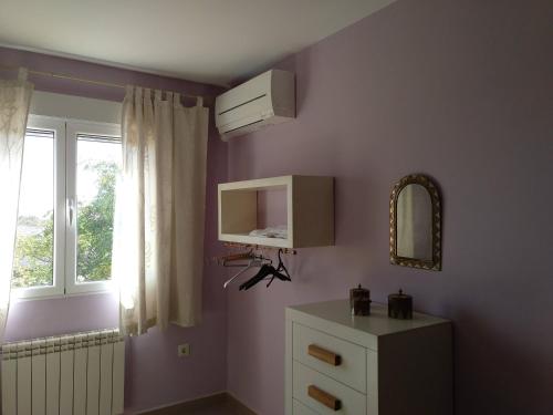 a room with a dresser and a mirror and a window at La Cuesta Blanca in Valdeganga