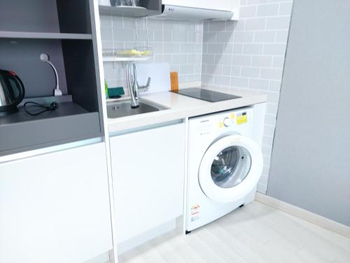 a laundry room with a washer and dryer at ARA Palace Hotel in Jeju