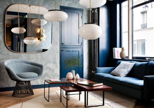 een woonkamer met een blauwe bank en een blauwe stoel bij Hôtel Henriette in Parijs