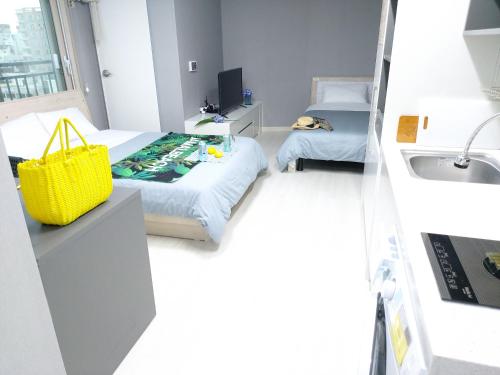 a small bedroom with a bed and a sink at ARA Palace Hotel in Jeju