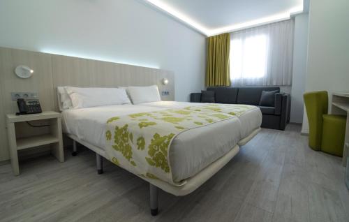 a hotel room with a large bed and a couch at Rambla Alicante Contactless in Alicante