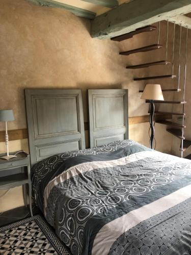 una camera da letto con due testiere, un letto e una scala di La Malcotais a Noyal-Châtillon-sur-Seich