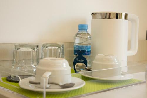 a glass counter top with a bottle of water and two dishes at Rambla Alicante Contactless in Alicante
