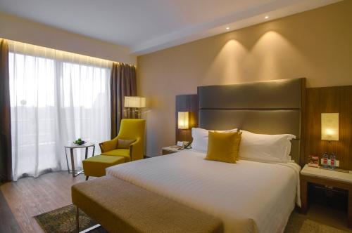 a hotel room with a large bed and a chair at Crowne Plaza Nairobi Airport by IHG in Nairobi