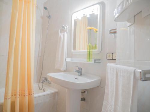 Baño blanco con lavabo y espejo en Apartamentos Playa Cargador, en Alcossebre