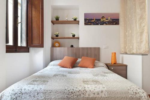 sypialnia z łóżkiem z pomarańczowymi poduszkami w obiekcie San Giuseppe Nido we Florencji