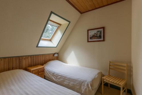 een slaapkamer met 2 bedden en een raam bij Kozakkenhoeve Dalen in Dalen