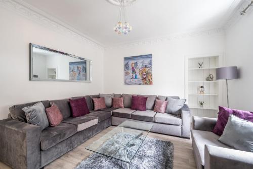 sala de estar con sofá marrón y almohadas moradas en Casa Fresa - Union Heights, en Dundee