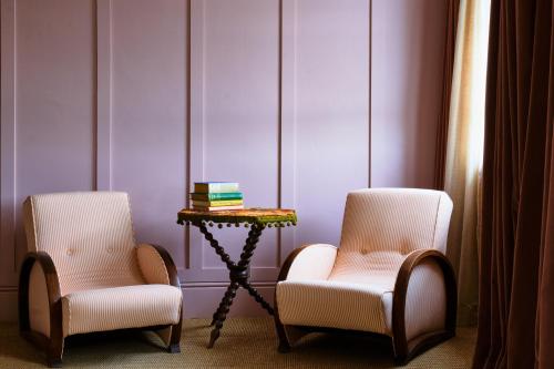 two chairs and a side table in a room at The Mitre, Hampton Court in Kingston upon Thames