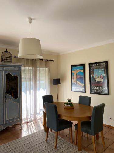 a dining room with a wooden table and chairs at Poço do Bispo 28 in Tavira