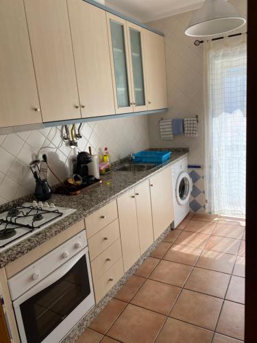 a kitchen with white cabinets and a stove top oven at Poço do Bispo 28 in Tavira