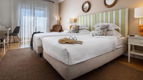 a bedroom with a bed with a pair of glasses on it at Pousada de Sagres in Sagres