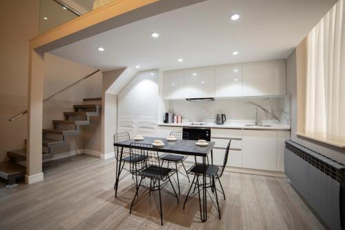 a kitchen with a table and chairs and a staircase at Prime Suites Bulvar in Baku