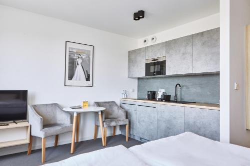 kuchnia ze stołem i 2 krzesłami w pokoju w obiekcie Silesia Apartments w mieście Katowice