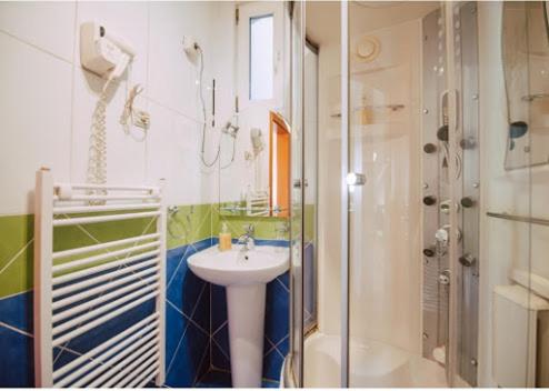 a bathroom with a sink and a shower at Car Royal Apartments and Rooms in Novi Sad