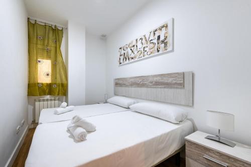 ein weißes Schlafzimmer mit 2 Betten und einem Schreibtisch in der Unterkunft Central and modern- 2 bedrooms 1 bathroom - MintyStay- Sol in Madrid