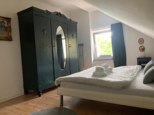 een slaapkamer met een bed en een kast met een spiegel bij Sascha´s Home in Saarlouis