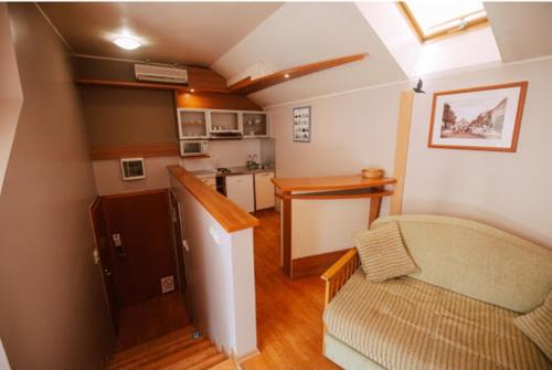 a living room with a couch and a kitchen at Car Royal Apartments and Rooms in Novi Sad