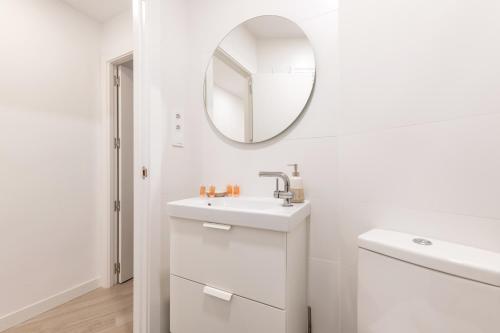 Baño blanco con lavabo y espejo en Bright and modern- 2 bedrooms 1bathroom- MintyStay - Bocángel en Madrid