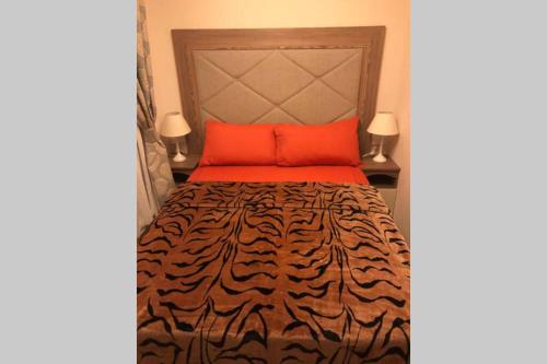 a bedroom with a tiger print bedspread and orange pillows at Mablethorpe Static Holiday Home in Mablethorpe