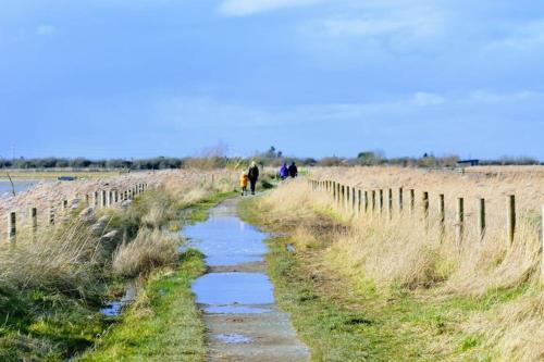 people walking down a dirt path next to a fence at Mablethorpe Static Holiday Home in Mablethorpe
