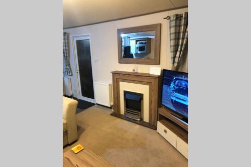 a living room with a television and a fireplace at Mablethorpe Static Holiday Home in Mablethorpe