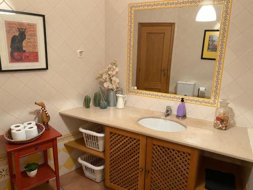 uma casa de banho com um lavatório e um espelho em Poço do Bispo 28 em Tavira