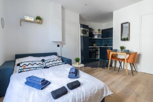 - une chambre avec un lit et des serviettes dans l'établissement Charmant studio au coeur de Paris, à Paris