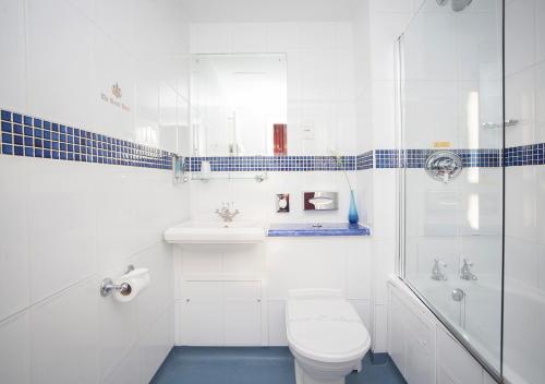 a white bathroom with a toilet and a shower at The Royal Hotel in Weston-super-Mare