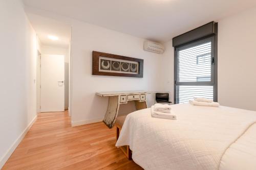een witte kamer met een bed en een bureau bij MintyStay - Felipe Campos in Madrid